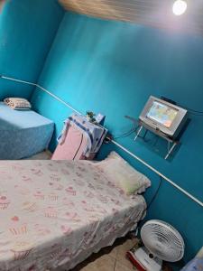 Habitación con cama y mesa con monitor en Mel Pousada, en Macaé