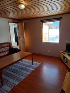 uma sala de estar com uma mesa e uma janela em Gula huset em Rottneros