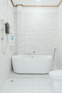 bagno bianco con vasca e servizi igienici di Tulip Hotel a Louang Namtha