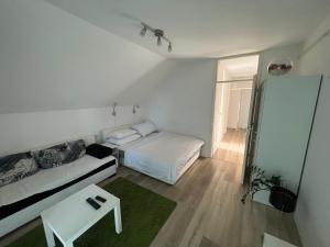 Plitvice Studio Sara في بليتفيتْشكا ييزيرا: غرفة نوم بيضاء صغيرة بها سرير وطاولة
