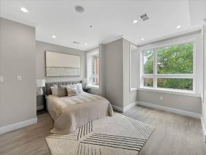 a white bedroom with a bed and a window at Modern Meridian 2 Bedroom (Chapin 3) in Washington, D.C.