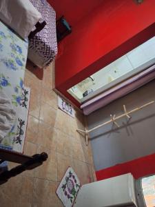 Habitación con vistas a un baño con paredes rojas y una ventana. en Mel Pousada, en Macaé