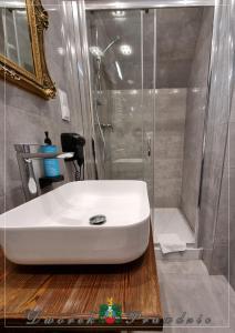 La salle de bains est pourvue d'un lavabo blanc et d'une douche. dans l'établissement Dworek Prawdzic Niechorze, à Niechorze