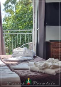 2 camas con toallas delante de una ventana en Dworek Prawdzic Niechorze, en Niechorze