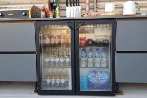 una nevera llena de botellas de agua y refrescos en Deganwy Beach house 3BR, en Deganwy