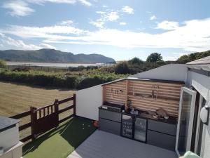 a kitchen on a deck with a view of the beach at Seaside Escape - Deganwy Beach Cottage - Sea Views & Golf Course Views in Deganwy