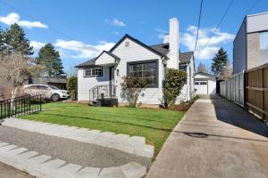 a white house with a fence and a yard at Picture Perfect Bungalow in the heart of DT Vancouver in Vancouver