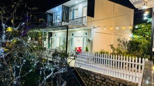 a house with a white fence in front of it at Nhà của Sóc in Da Lat