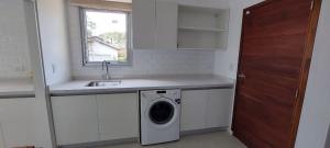 a kitchen with a sink and a washing machine at Casa SHANTI in Pinamar +26 photos
