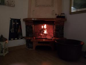 un camino con un fuoco in una stanza di Villetta Coccinella a Nettuno