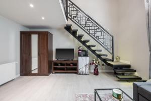 ein Wohnzimmer mit einer Treppe und einem TV in der Unterkunft Szent István Apartments in Budapest