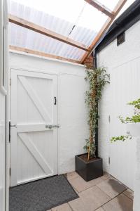 a white garage with a barn door and a potted plant at 1908 the Gardens in Belfast