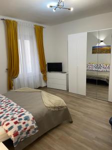 Schlafzimmer mit einem Bett, einem TV und einem Spiegel in der Unterkunft Savonarola residence in Alessandria