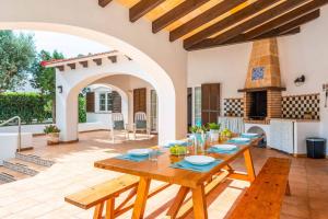 uma sala de jantar com uma mesa de madeira e um arco em Villa Juana Blanes em Cala en Blanes