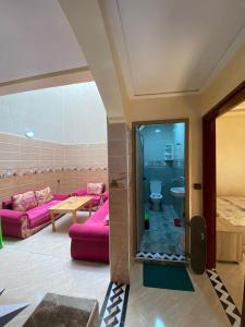 Una sala de estar con un sofá rosa y una mesa. en Sun house, en Imsouane