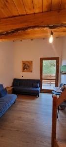 una sala de estar con sofás azules y techo de madera. en Campaegli resort, en Campaegli