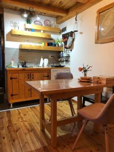 a kitchen with a wooden table and a kitchen counter at Apartman Čivović in Rudnik Kačerski