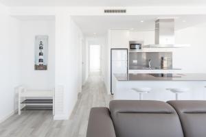 a white kitchen with a couch and a counter at Vista Roses Mar - Vent De Mar in Roses