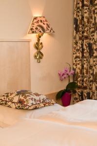 a bedroom with a bed and a lamp and flowers at Gästehaus Hochtirol in Vorderlanersbach