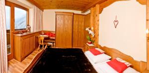 ein Schlafzimmer mit einem Bett und einem Schreibtisch in einem Zimmer in der Unterkunft Gästehaus Hochtirol in Vorderlanersbach