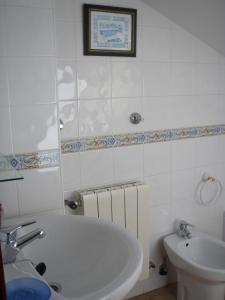 un bagno bianco con vasca e lavandino di Hostal Pineda a Cervera de Pisuerga