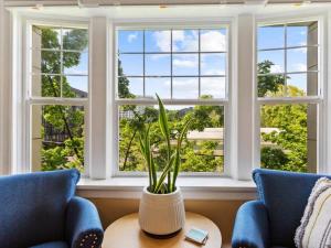 ポートランドにあるNW Studio with a Viewの青い椅子2脚、テーブル、窓が備わる客室です。