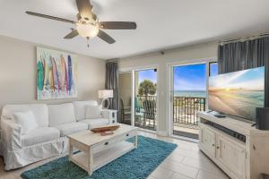 a living room with a white couch and a flat screen tv at Windancer 202 in Destin