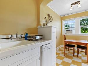 eine Küche mit einem weißen Waschbecken und einem Tisch in der Unterkunft NW Studio with a View in Portland