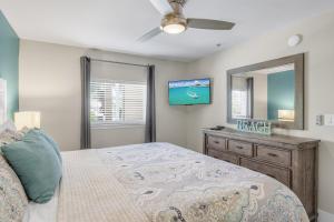 a bedroom with a bed and a dresser and a mirror at Windancer 202 in Destin +22 photos