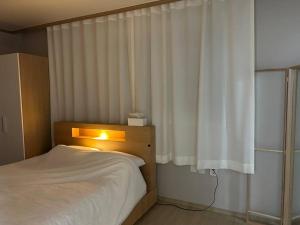 a bedroom with a bed and a window with a light at Haru Airport Stay Gimpo in Seoul