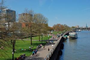 a group of people walking on a sidewalk next to a river at NW Studio with a View in Portland +8 photos