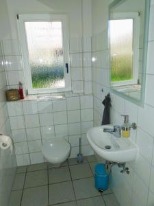 a white bathroom with a sink and a toilet at FeWo im Ried.Schwanau in Schwanau