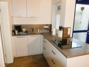 a kitchen with white cabinets and a sink at FeWo im Ried.Schwanau in Schwanau