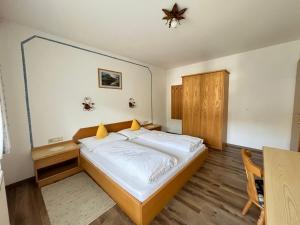 1 dormitorio con 1 cama grande y armario de madera en Am Dörfl en Tux