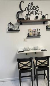 eine Küche mit 2 Stühlen und einem Tisch mit einem Kaffeeschild an der Wand in der Unterkunft Pet Friendly, 30+ Night Stay in Johnson City