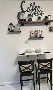 a kitchen with two chairs and a table with a coffee sign on the wall at Pet Friendly, 30+ Night Stay in Johnson City