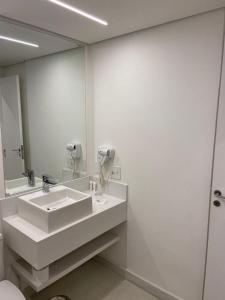 a bathroom with a sink and a mirror at Flat Hotel in Sao Paulo