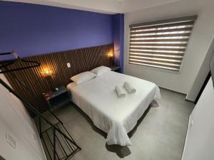 a bedroom with a bed with two towels on it at Casa Arte Coliving in Pereira
