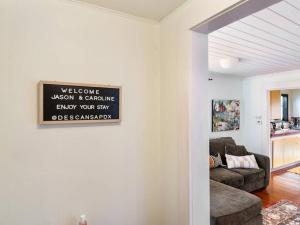 a living room with a couch and a sign on the wall at Casa del Sol - Walk to Alberta Arts District in Portland