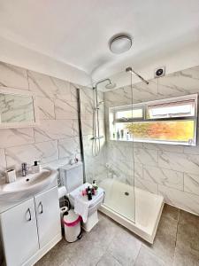 La salle de bains est pourvue d'un lavabo, de toilettes et d'une douche. dans l'établissement Luxurious family home in West Midlands, à Northfield