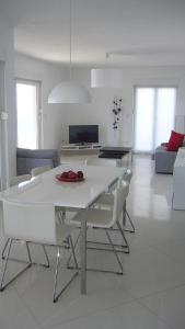 un tavolo da pranzo bianco e sedie in soggiorno di Feelgood Apartments a Podstrana