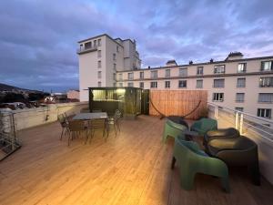 Un balcón con mesas y sillas en un edificio en Appartement superbe Rooftop 70m2 Clermont Ferrand, en Clermont-Ferrand