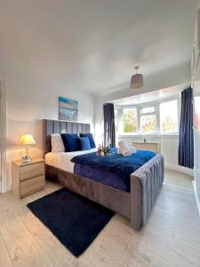 a bedroom with a large bed with blue sheets at Luxurious family home in West Midlands in Northfield