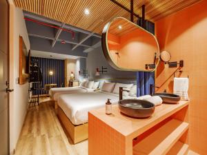 a bedroom with a bed and a sink and a mirror at The Somos Bold Hotel in Medellín