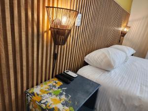 een hotelkamer met een bed en een tafel met twee afstandsbedieningen bij Casa Arte Coliving in Pereira
