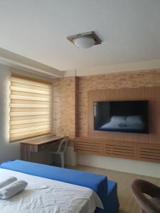 a bedroom with a tv and a bed and a desk at Amaia Steps Capitol Central N814 in Bacolod +17 photos