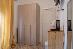 ein Zimmer mit einem Holzschrank mit einem TV darauf in der Unterkunft L'angolo di Acitrezza in Acitrezza