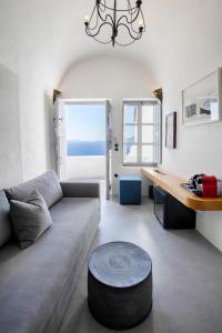 a living room with a couch and a desk at Ducato Di Oia in Oia