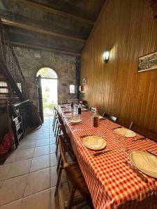 uma sala de jantar com uma mesa com uma toalha de mesa xadrez vermelha e branca em Bodega típica en El Molar sin camas ni dormitorios em El Molar
