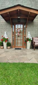 uma porta da frente de uma casa com dois vasos de plantas em Apartamento das Flores em Gramado